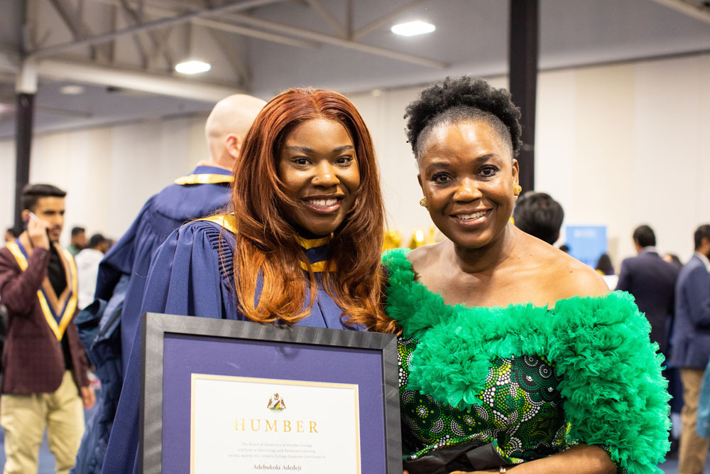 Grad posing with framed award