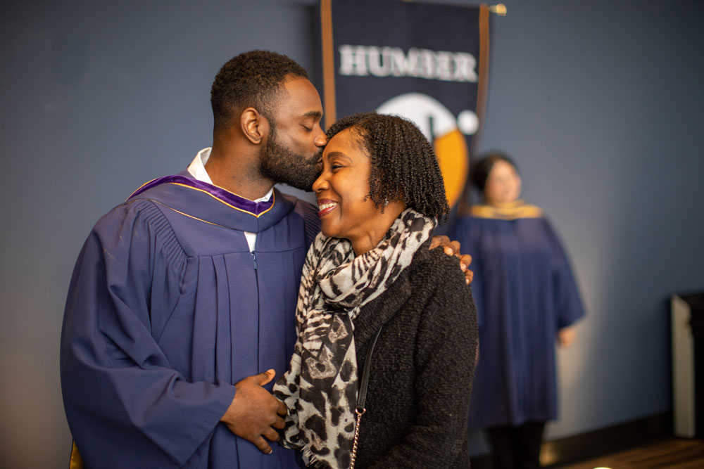 Grad kissing family member on their head