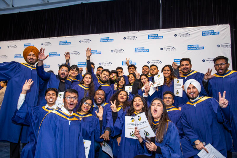 Large group of graduates make excited faces for camera