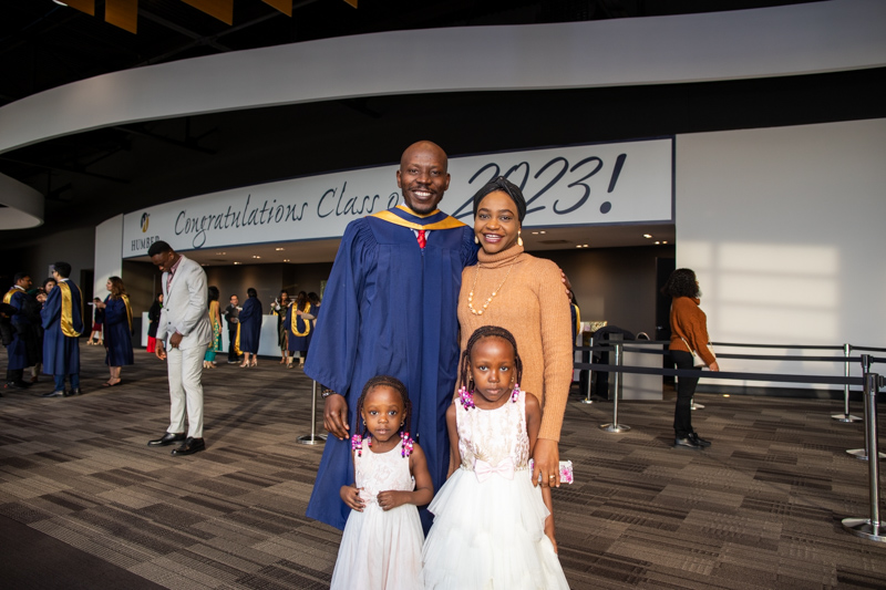 Graduate poses for photo with three family members
