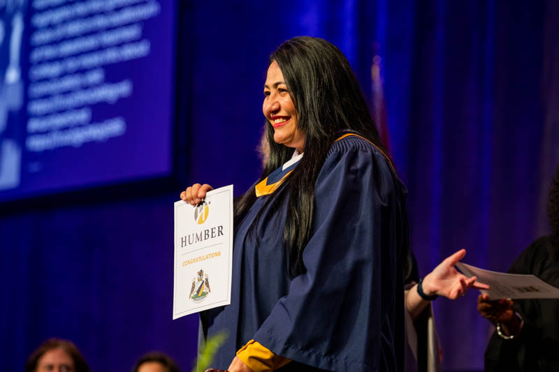 Graduate on stage smiling