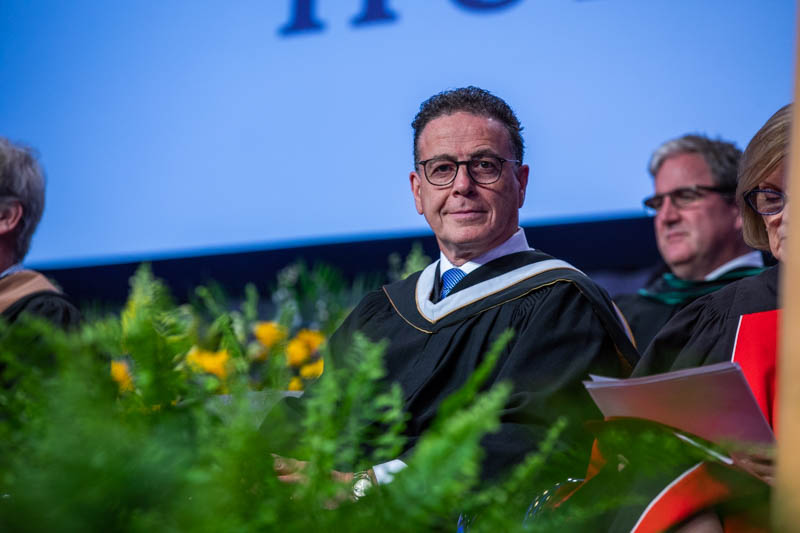 Honorary degree recipient Anthony Longo on stage looks at camera