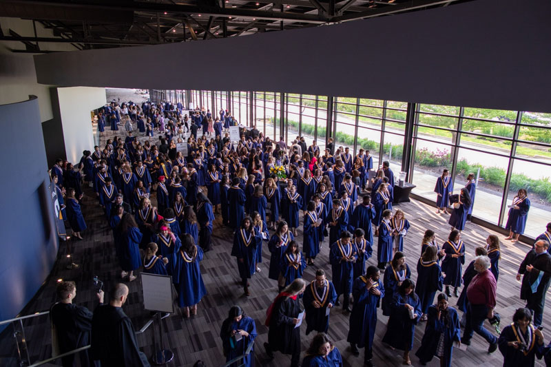 Overhead view of ceremony reception area filled with graduates in gowns