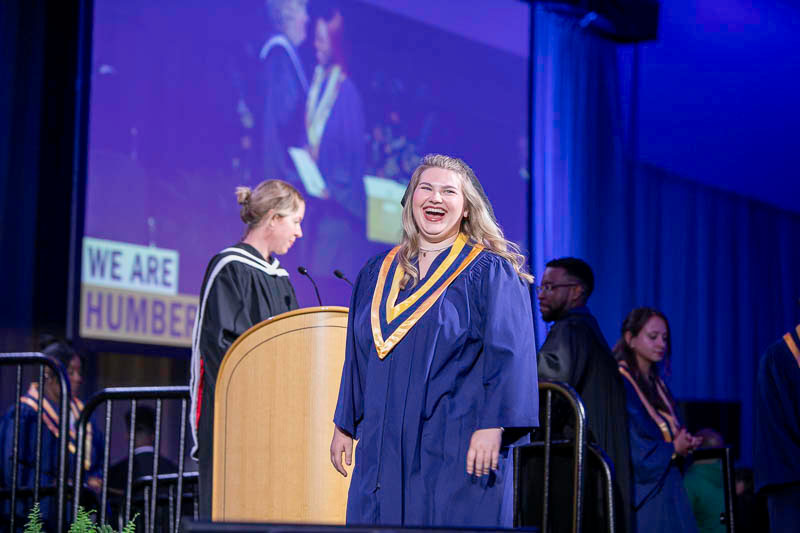 Graduate smiles as they cross stage