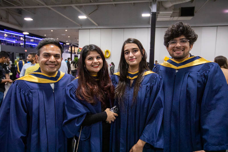 Four graduates pose for camera