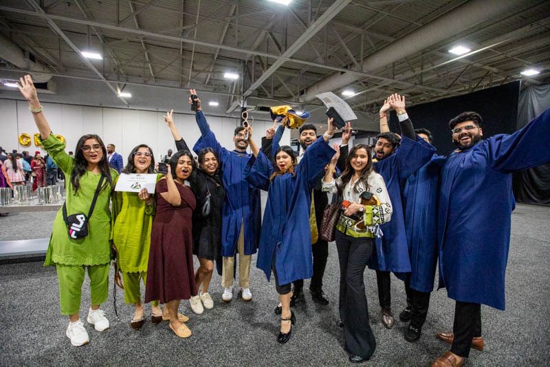 Eleven people raise their arms in excitement