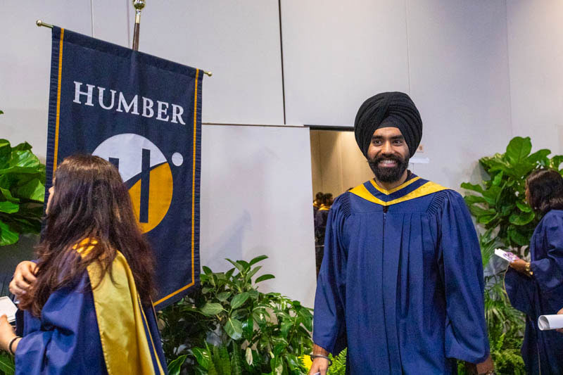Graduate smiles as they proceed in line