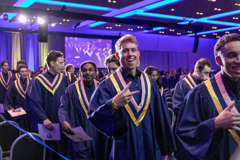 Graduate holds up peace sign