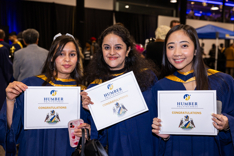 Students posing with diplomas