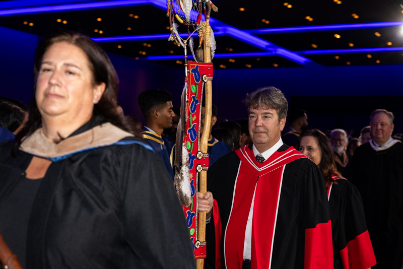 Person holding indigenous staff