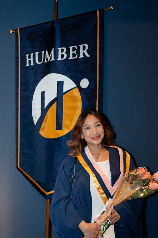 Student in front of Humber Flag