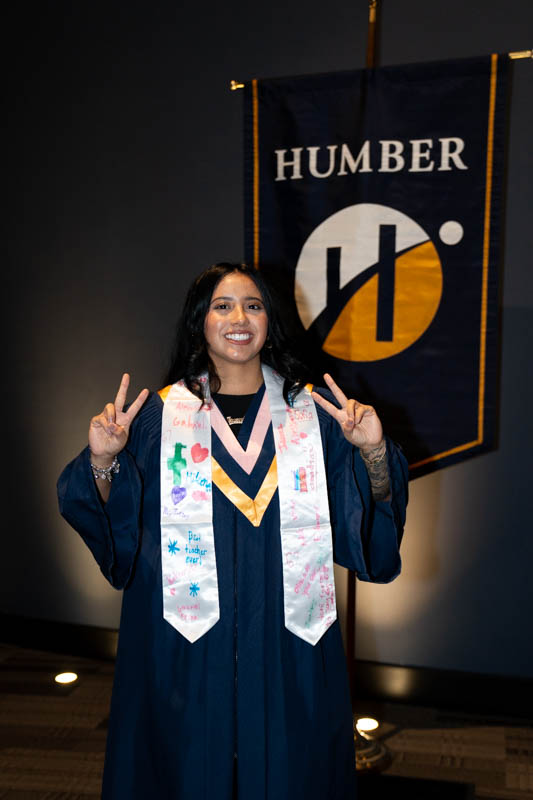 Student in front of Humber Flag