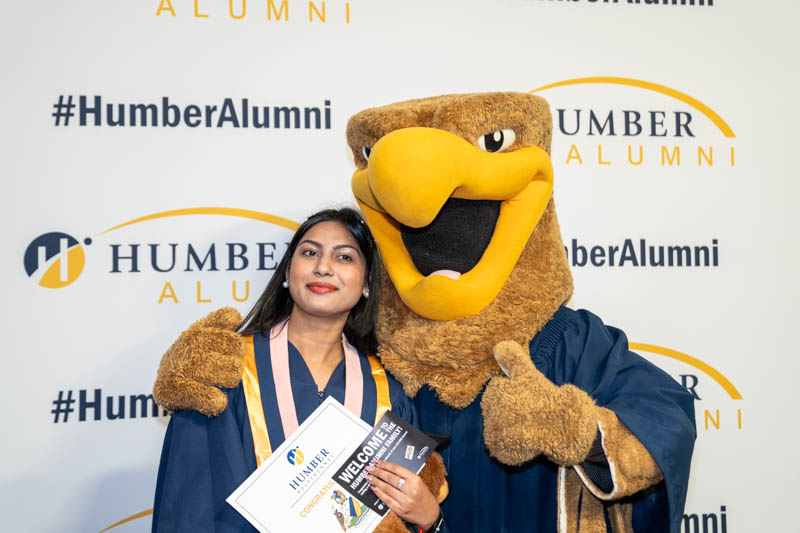 Student posing with mascot