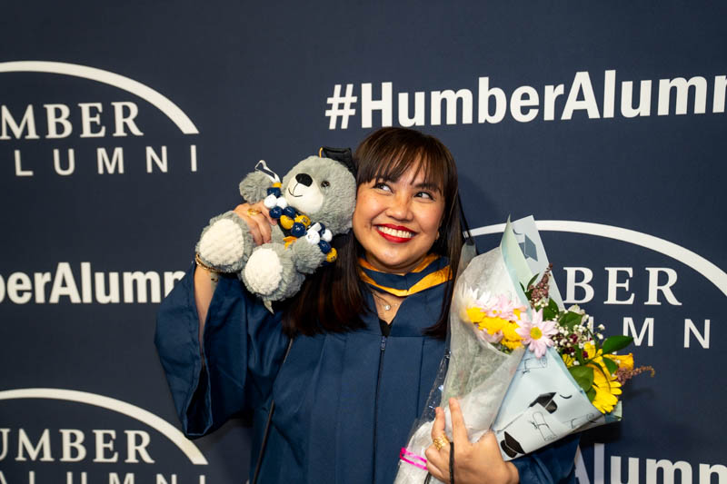 Student smiling with teddy bear