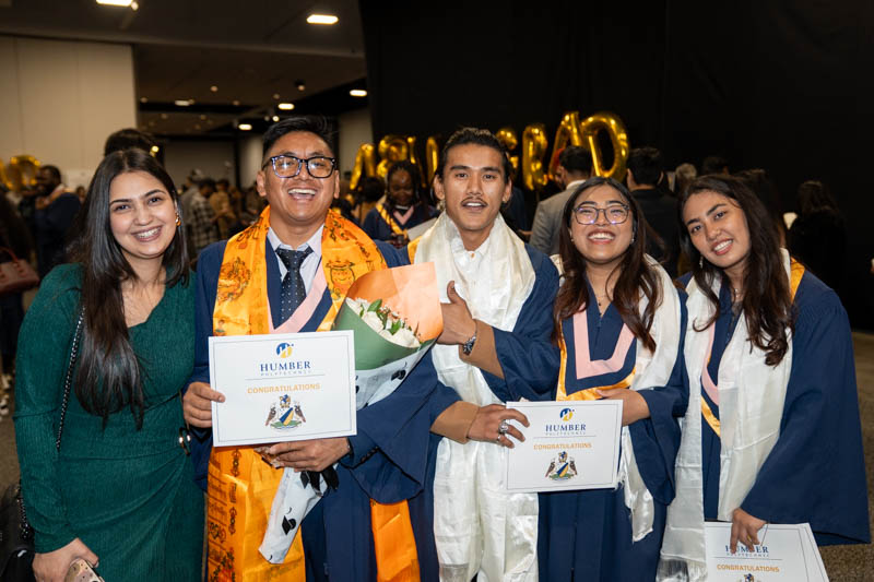 Students posing with diplomas