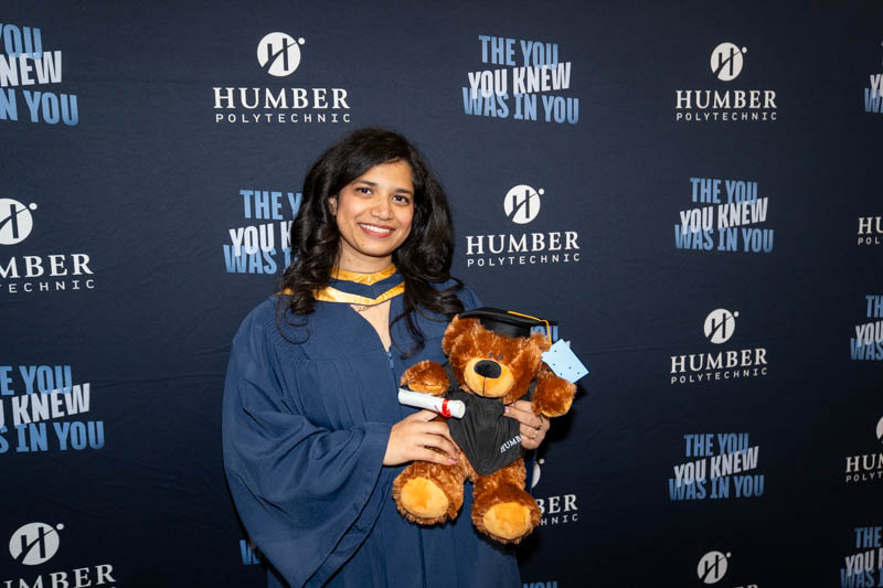 Student smiling with teddy bear