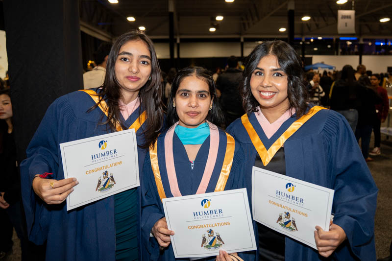 Students posing with diplomas