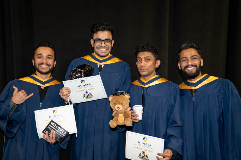 Students posing with diplomas