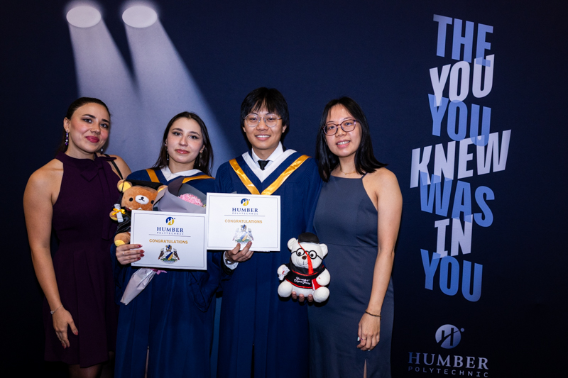 Students posing with Diplomas