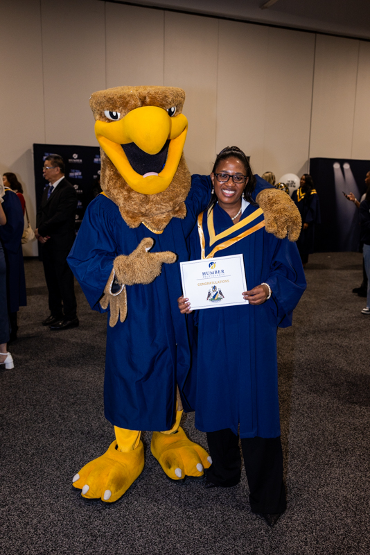 Student posing with mascot