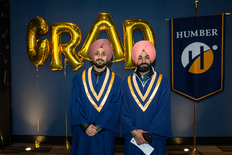 Students posing in front of Grad Balloons