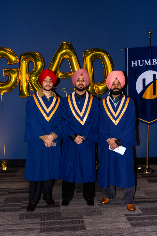 Students posing in front of Grad Balloons