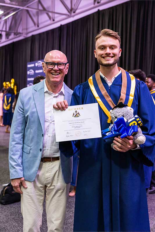 Student smiling holding diploma