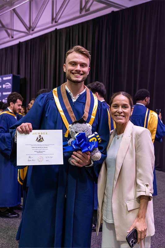Student smiling holding diploma