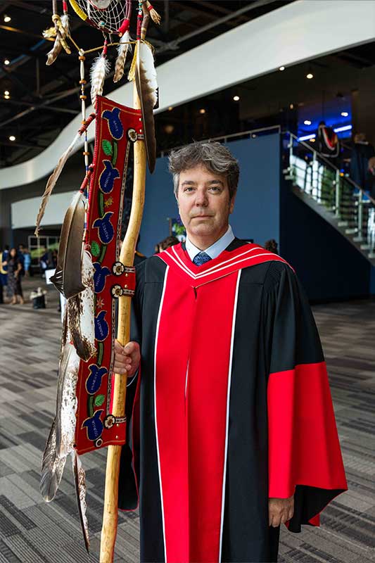 Person holding  indigenous ceremonial staff