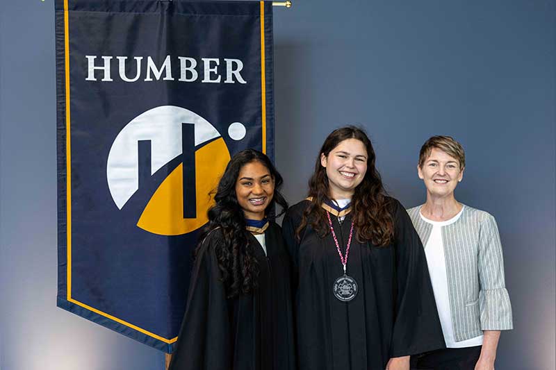 People posing in front of Humber Flag