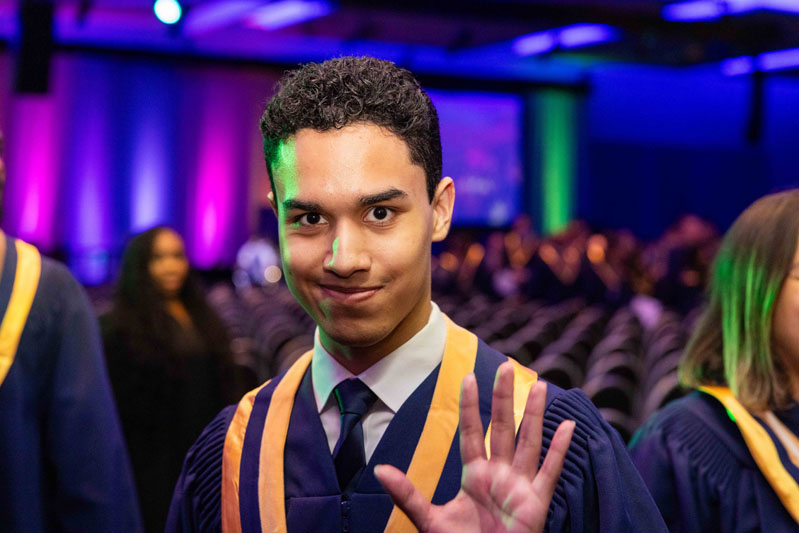 Student waving at camera