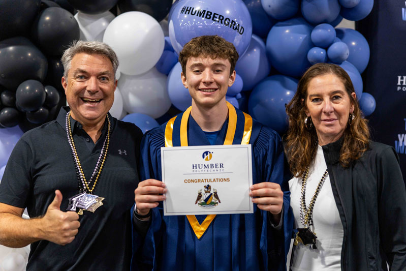 Student posing for picture with their diplomas