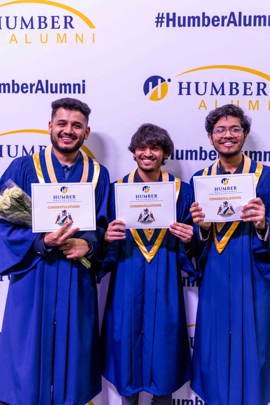 Student posing for picture with diplomas