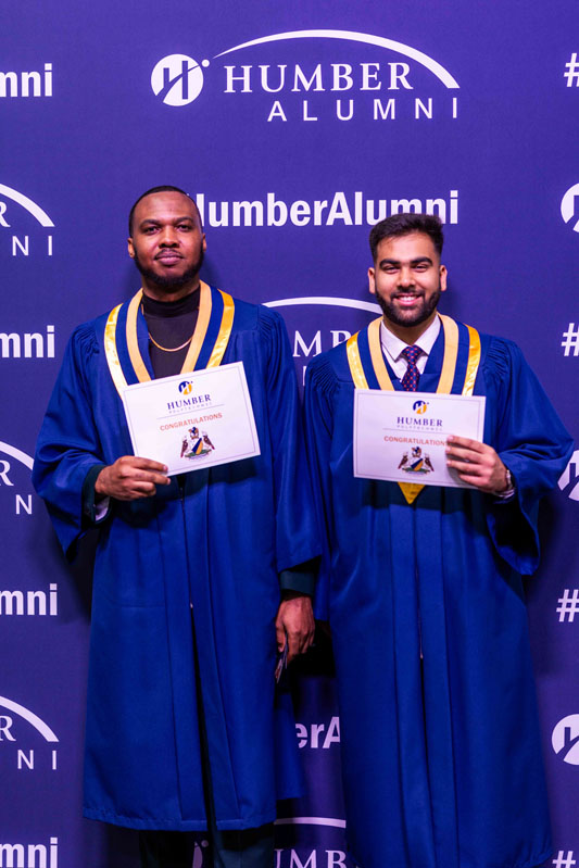 Student posing for picture with diplomas