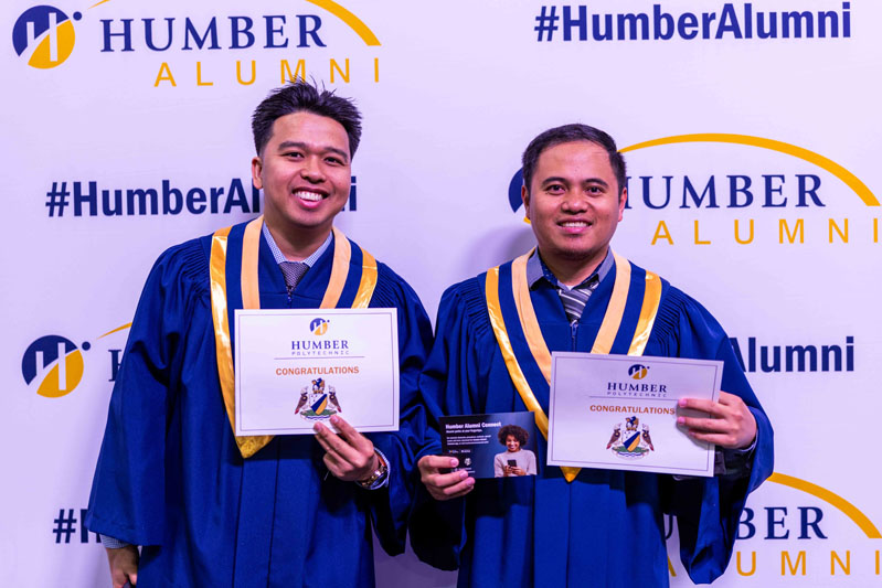 Student posing for picture with diplomas