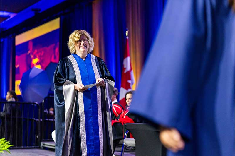 Humber President Holding Diplomas on stage
