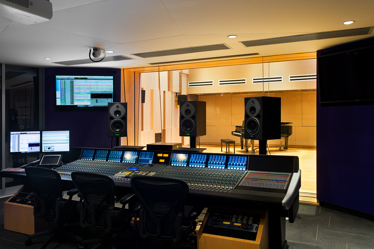 Studio control room with large mixing board and audio monitors