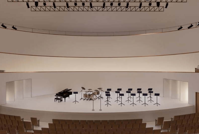 Architect's rendering of a large performance space with musical instruments on stage
