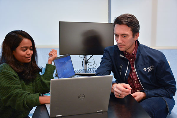 Two people looking at laptop