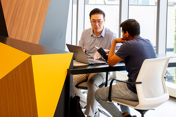 People talking and looking at computer