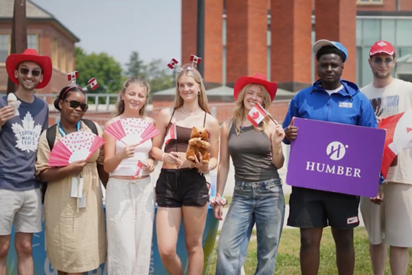 7 students standing in a line holding items
