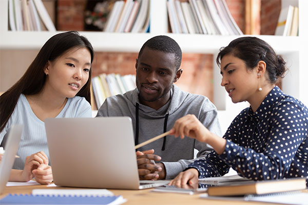 3 people looking at a laptop