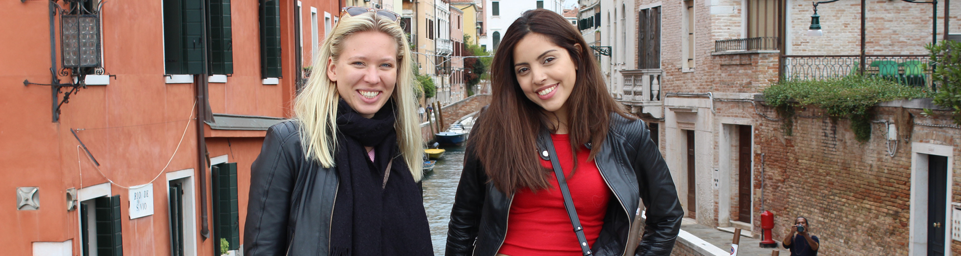 Two people standing on bridge smiling