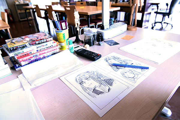 Desk with portraits sketched out on paper