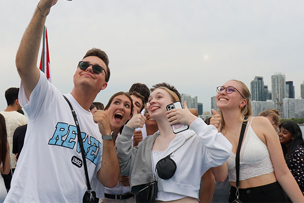 4 students taking a selfie on a boat