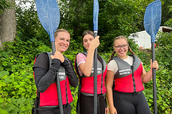 three GSS students smiling with paddles