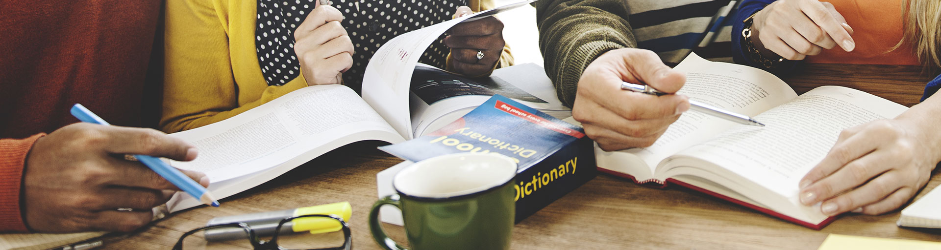 people flipping through books at a desk
