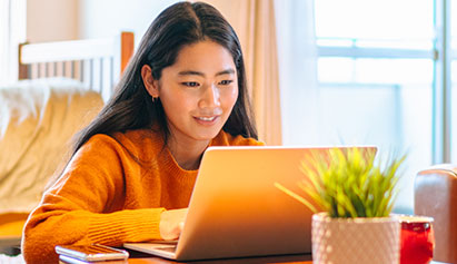 Female student on a laptop in her bedroom
