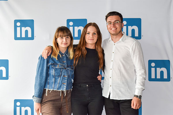 two females and a male taking a photo