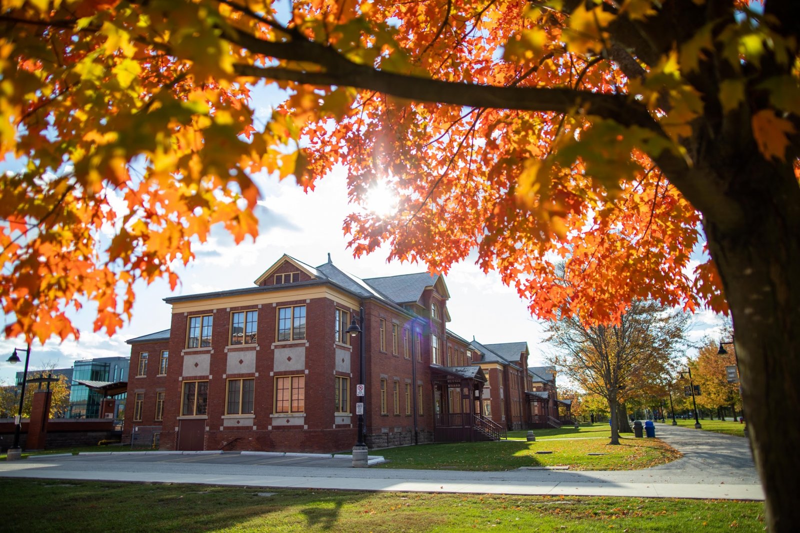 Exterior view of Humber's Lakeshore campus with colourful fall leaves in the foreground.